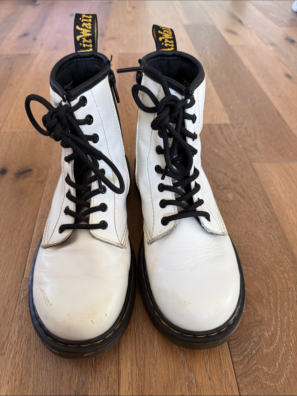 Dr. Martens White Leather Lace-Up Combat Boots with Black Accents.